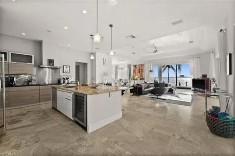 a kitchen with stainless steel appliances kitchen island a large island in the center and a view of living room