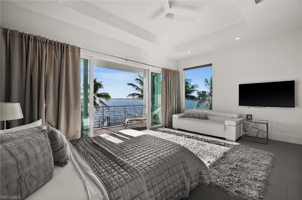 5625 Riverside Drive Cape Coral, FL 33904 - Photo 47 of 50 a bedroom with a bed and a flat screen tv