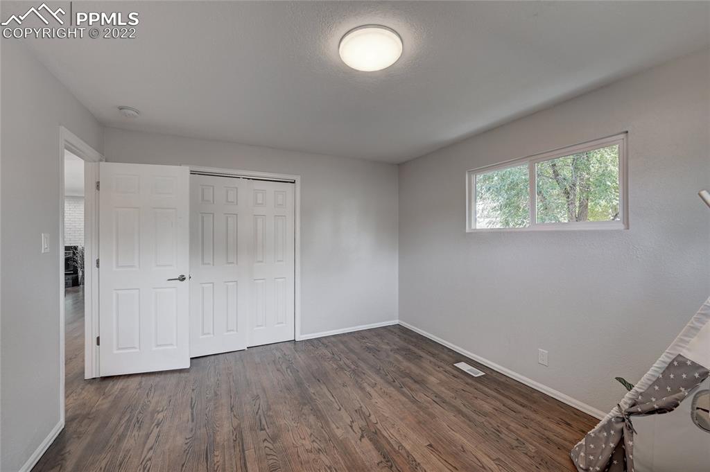 505 Inca Drive Colorado Springs, CO 80911 - Photo 11 of 33 an empty room with wooden floor and windows