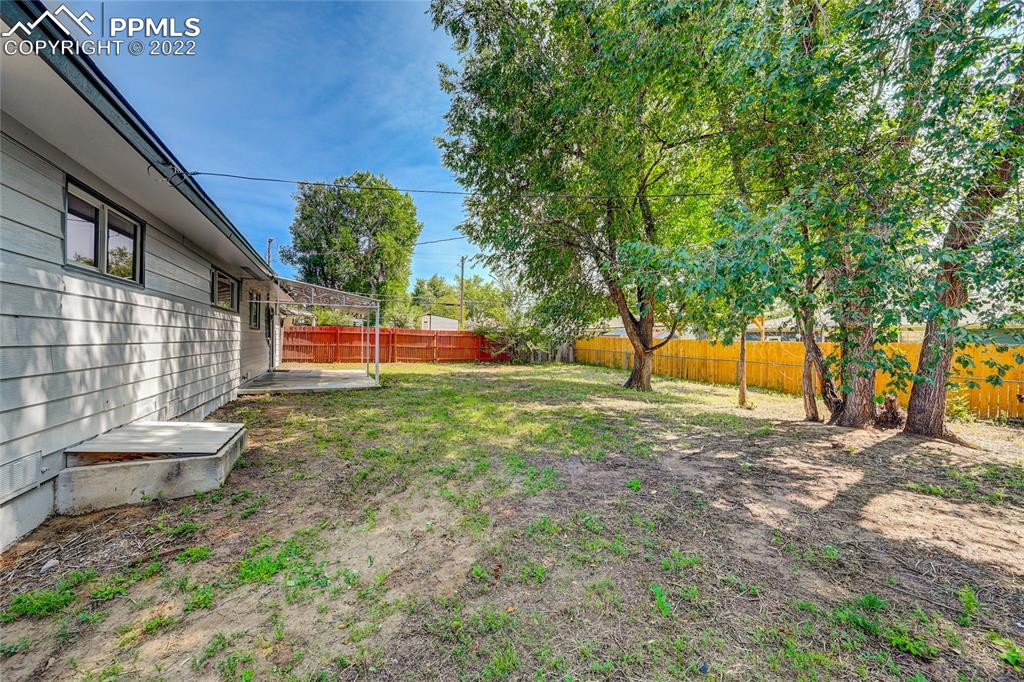 505 Inca Drive Colorado Springs, CO 80911 - Photo 19 of 33 a backyard of a house with large trees and plants