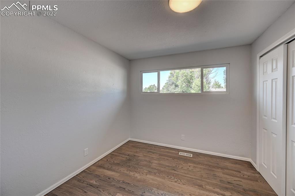 505 Inca Drive Colorado Springs, CO 80911 - Photo 24 of 33 an empty room with wooden floor and windows