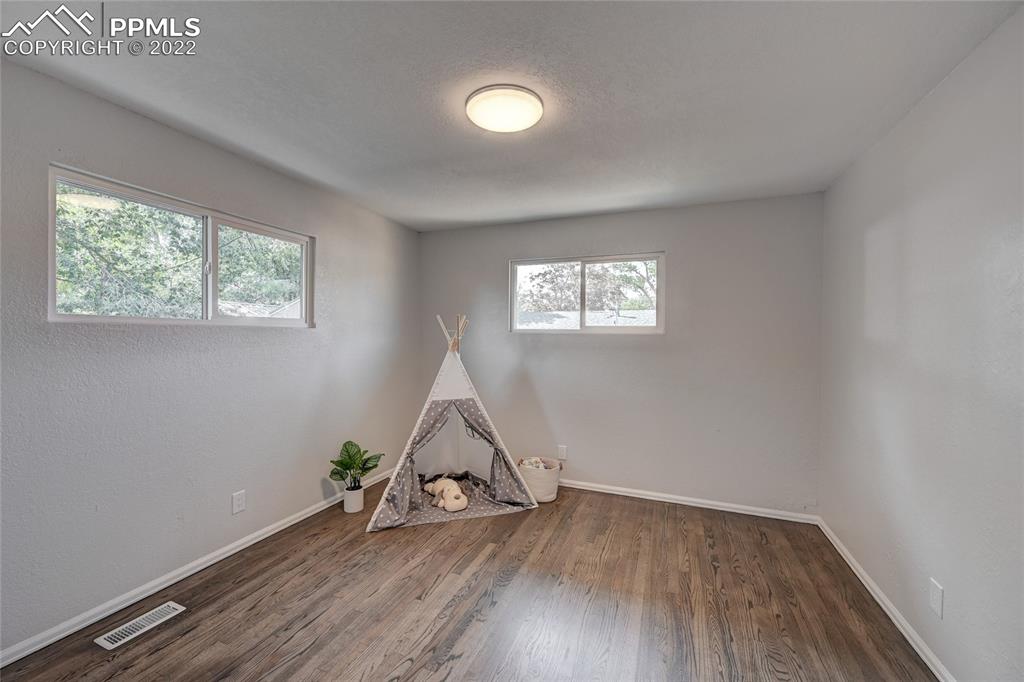 505 Inca Drive Colorado Springs, CO 80911 - Photo 25 of 33 an empty room with wooden floor and windows