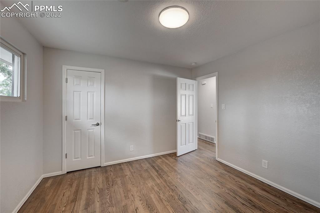 505 Inca Drive Colorado Springs, CO 80911 - Photo 26 of 33 an empty room with wooden floor and windows