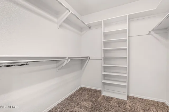 a view of walk in closet with empty racks