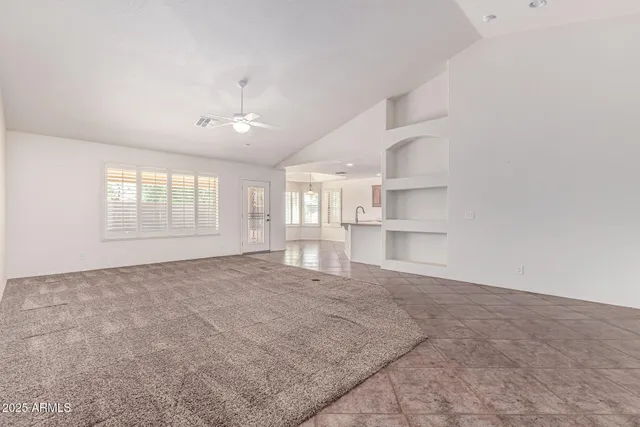 an empty room with windows and cabinet