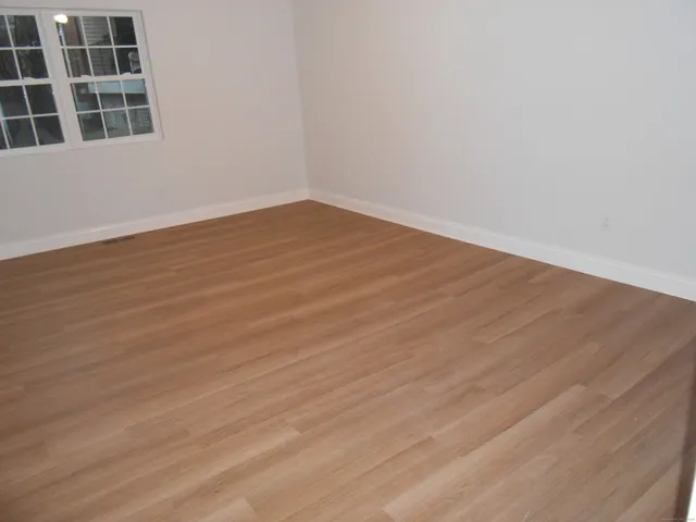 a view of an empty room with wooden floor