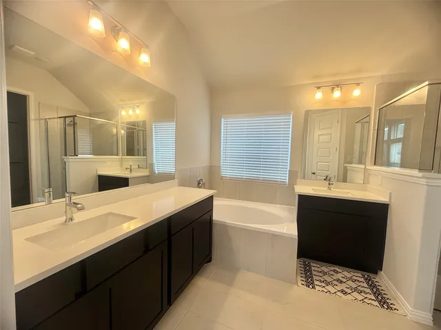 a bathroom with a tub sink and mirror