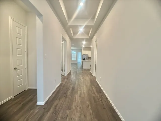 a view of a hallway with wooden floor