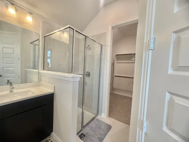 a bathroom with a double vanity sink mirror and shower
