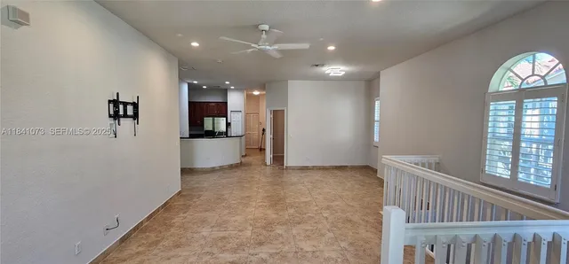 a view of a hallway with wooden floor and a kitchen space