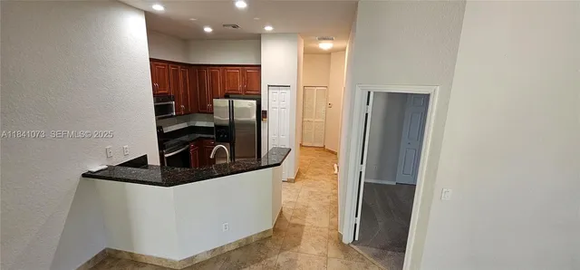 a kitchen with stainless steel appliances granite countertop a refrigerator and a sink