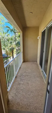 a view of a porch with wooden floor and door
