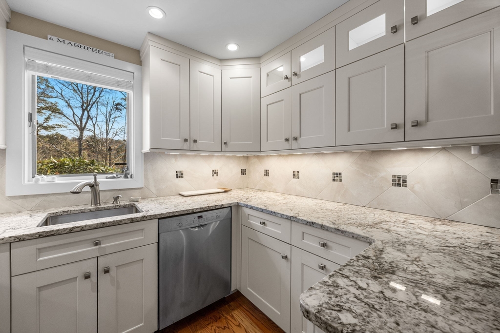 381 Great Oak Road, Unit 9 Mashpee, MA 02649 - Photo 6 of 42 a kitchen with granite countertop white cabinets and sink