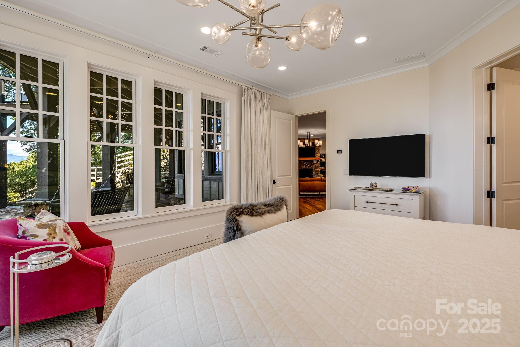 85 Back Bone Way, Unit 200 Sylva, NC 28779 - Photo 36 of 48 a bedroom with a bed a flat screen tv and a chandelier
