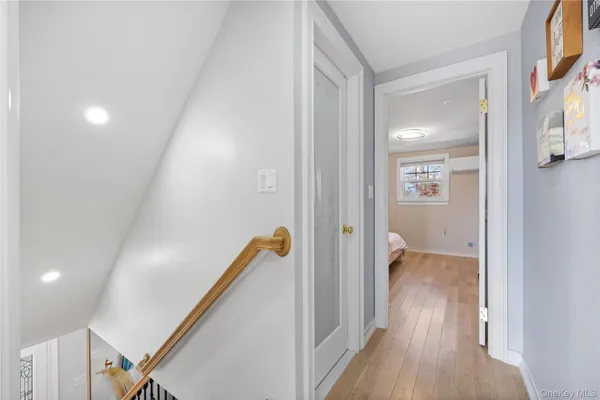 a view of a hallway with wooden floor and staircase