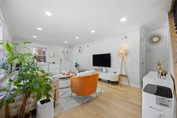 a living room with furniture a flat screen tv and a potted plant