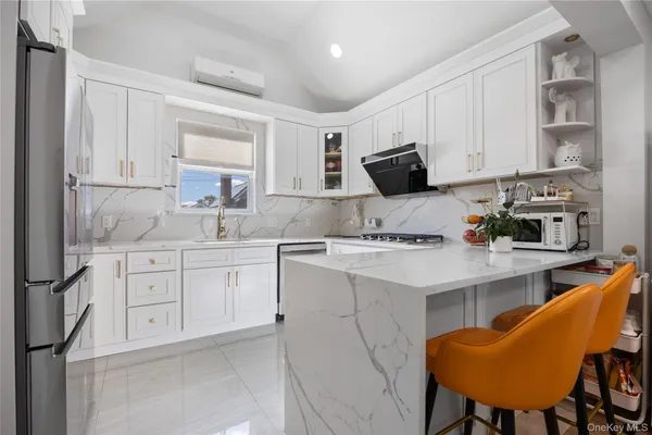 a kitchen with white cabinets and appliances