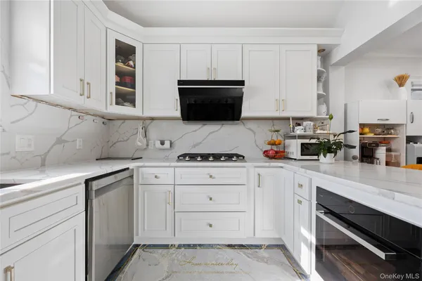 a kitchen with white cabinets and appliances