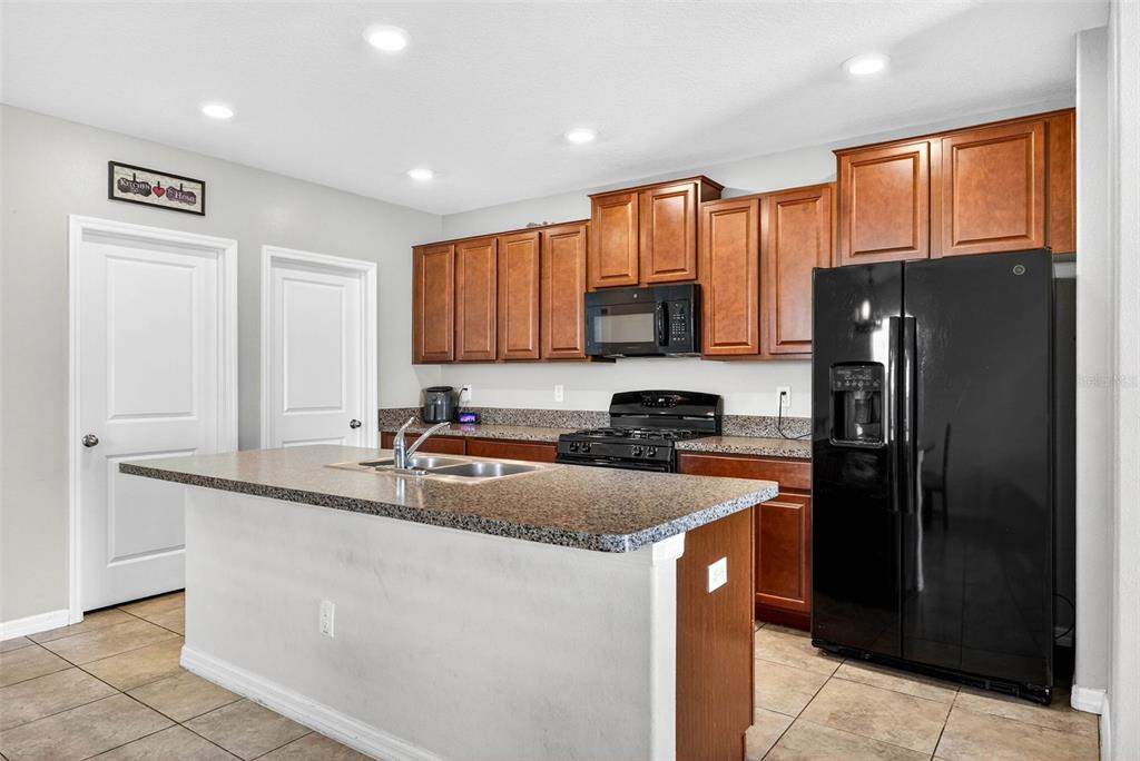 9616 Lemon Drop Loop Sun City Center, FL 33573 - Photo 11 of 53 a kitchen with stainless steel appliances granite countertop a refrigerator a sink a stove a microwave and island