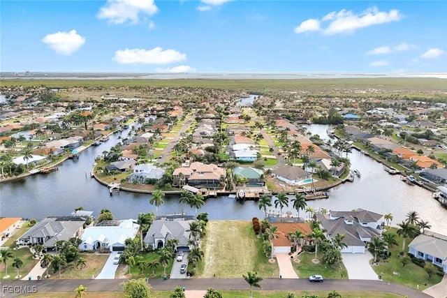 an aerial view of a house with a garden and lake view