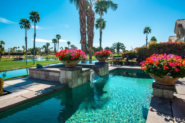 a view of a house with a big yard and potted plants