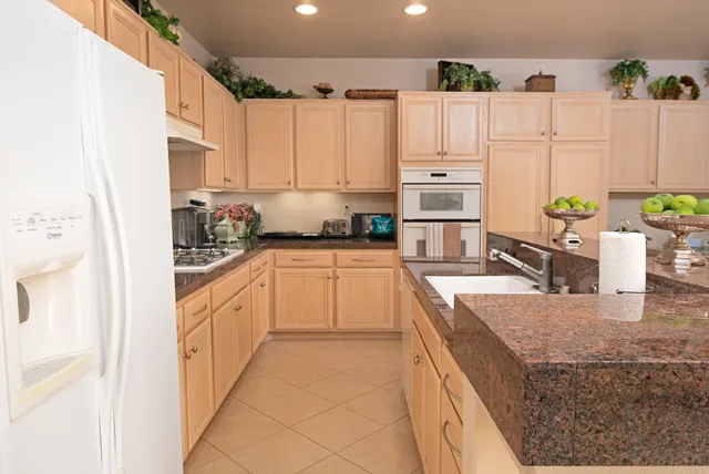 a kitchen with granite countertop a sink stove and cabinets