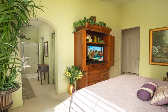 a bedroom with a bed and a potted plant