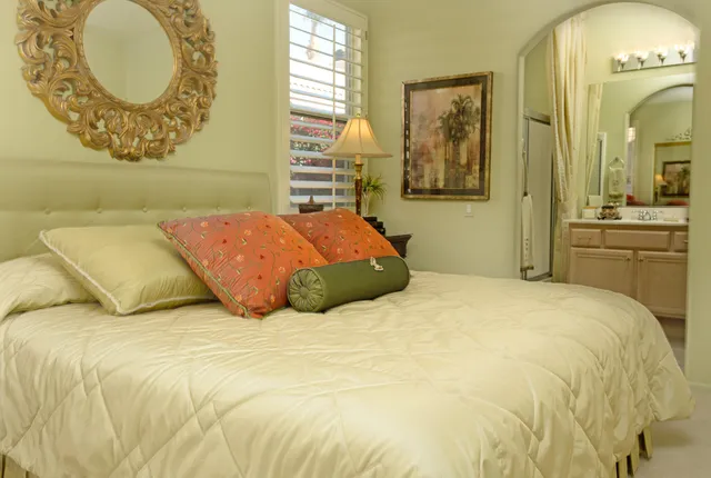 a bedroom with a bed and dresser with mirror