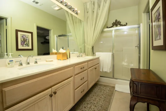 a spacious bathroom with a double vanity sink a mirror and a bathtub