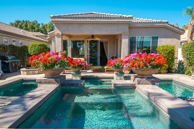 a front view of house and yard with beautiful flowers