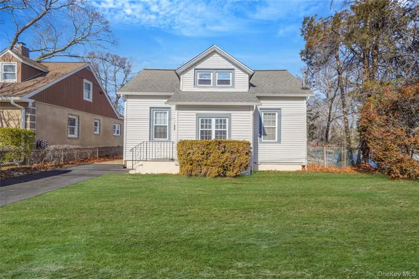 a view of a house with a big yard and large trees
