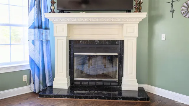 a kitchen with stainless steel appliances kitchen island granite countertop a refrigerator a stove and oven with wooden floor