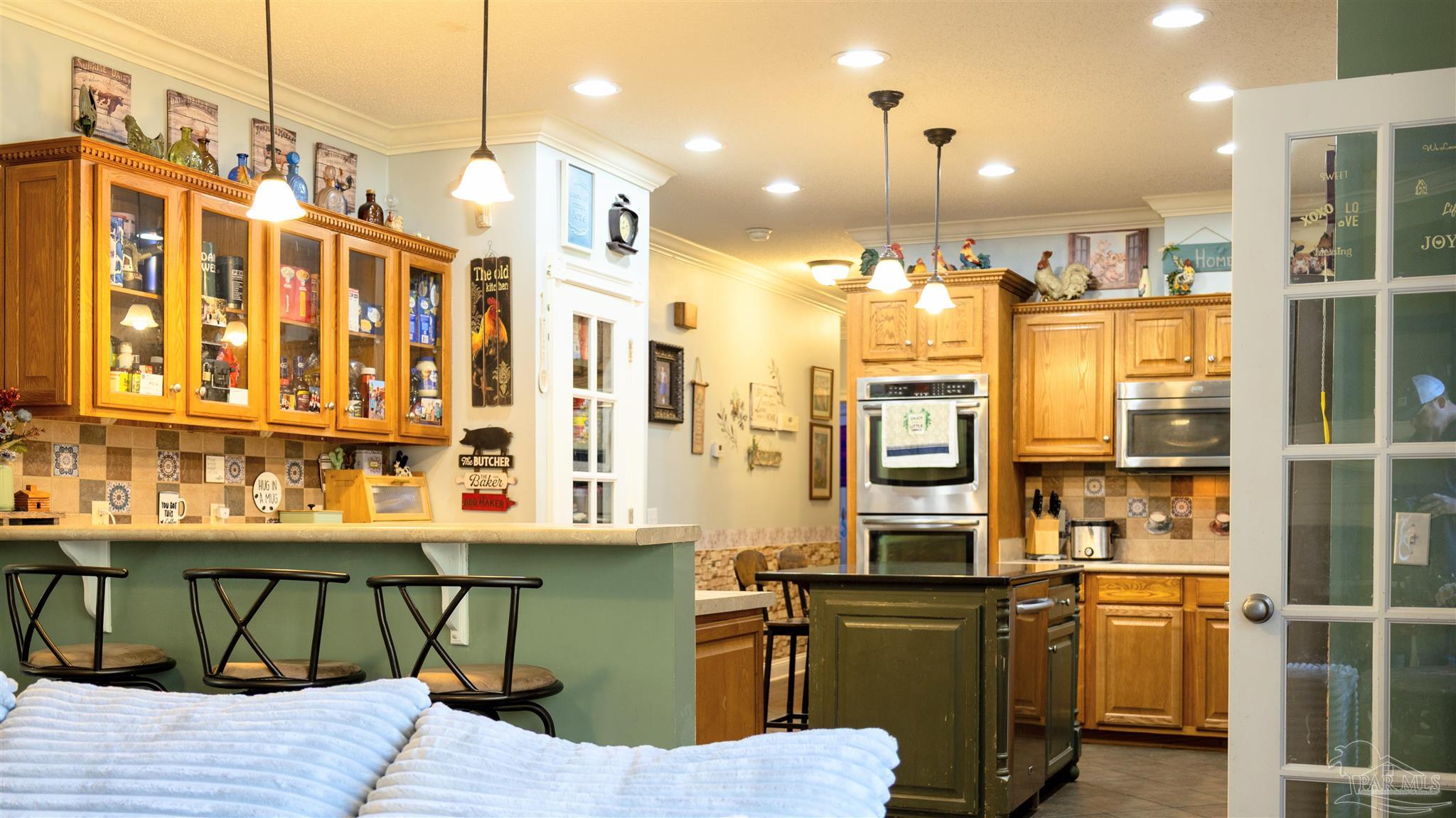 1700 Prospect Road Coffeeville, AL 36524 - Photo 22 of 71 a kitchen with stainless steel appliances kitchen island granite countertop a refrigerator a stove and oven with wooden floor