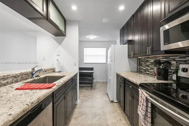 a kitchen with stainless steel appliances granite countertop a sink stove and refrigerator