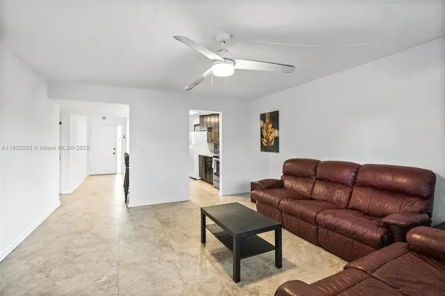 a living room with furniture and a ceiling fan