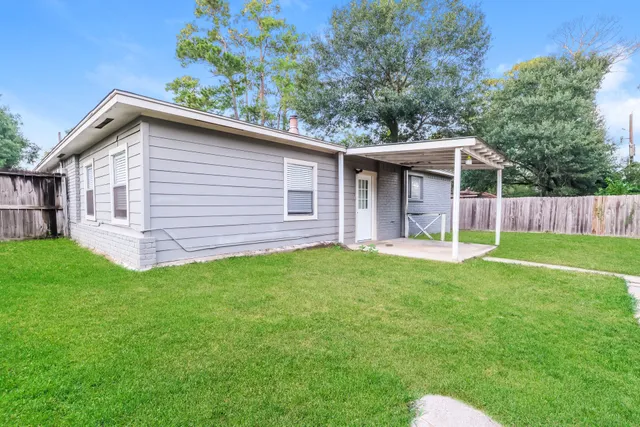 a backyard of a house with table and chairs