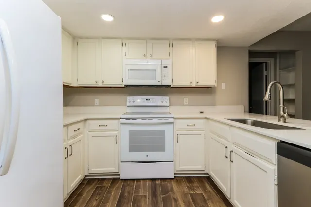 a kitchen with white cabinets appliances and sink