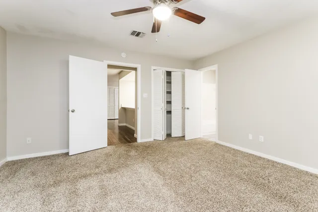 a view of empty room with ceiling fan