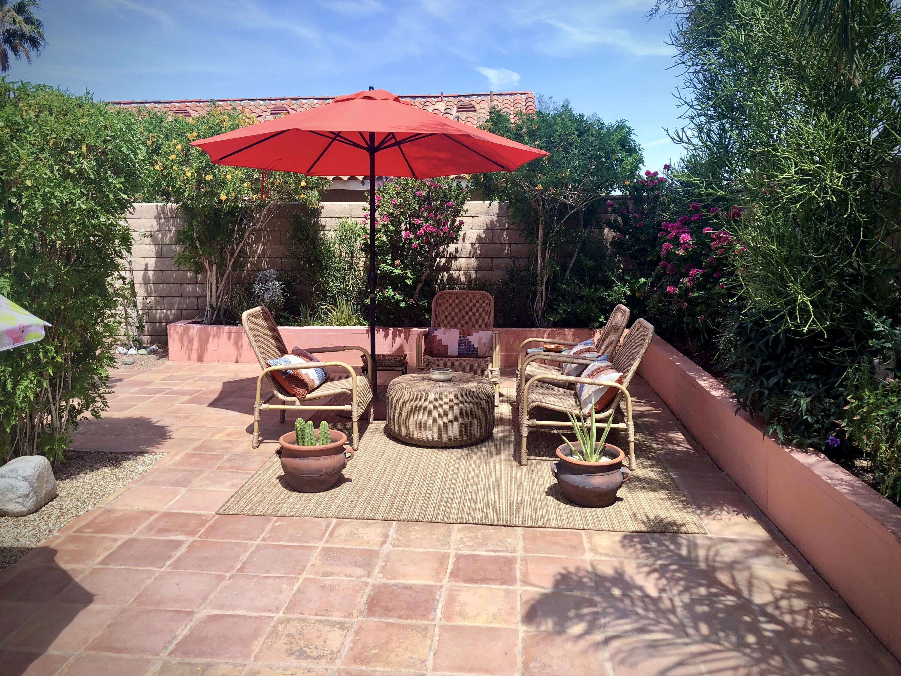1490 East Racquet Club Road Palm Springs, CA 92262 - Photo 4 of 29 a view of a patio with table and chairs under an umbrella