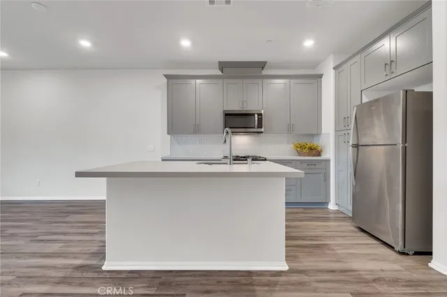a kitchen with stainless steel appliances granite countertop a refrigerator and a sink