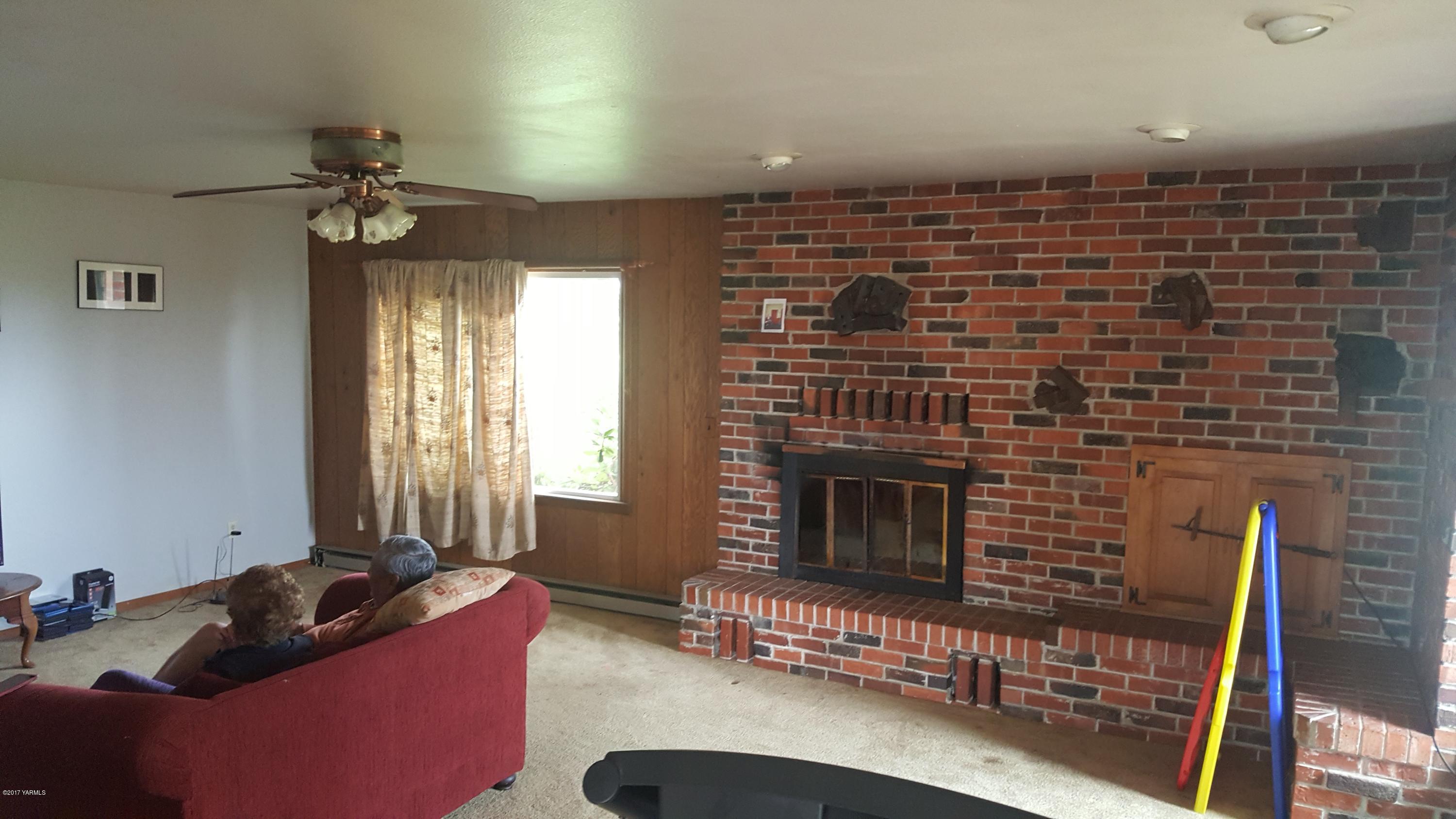 6530 Ashue Road Wapato, WA 98951 - Photo 2 of 14 a living room with furniture windows and a fireplace