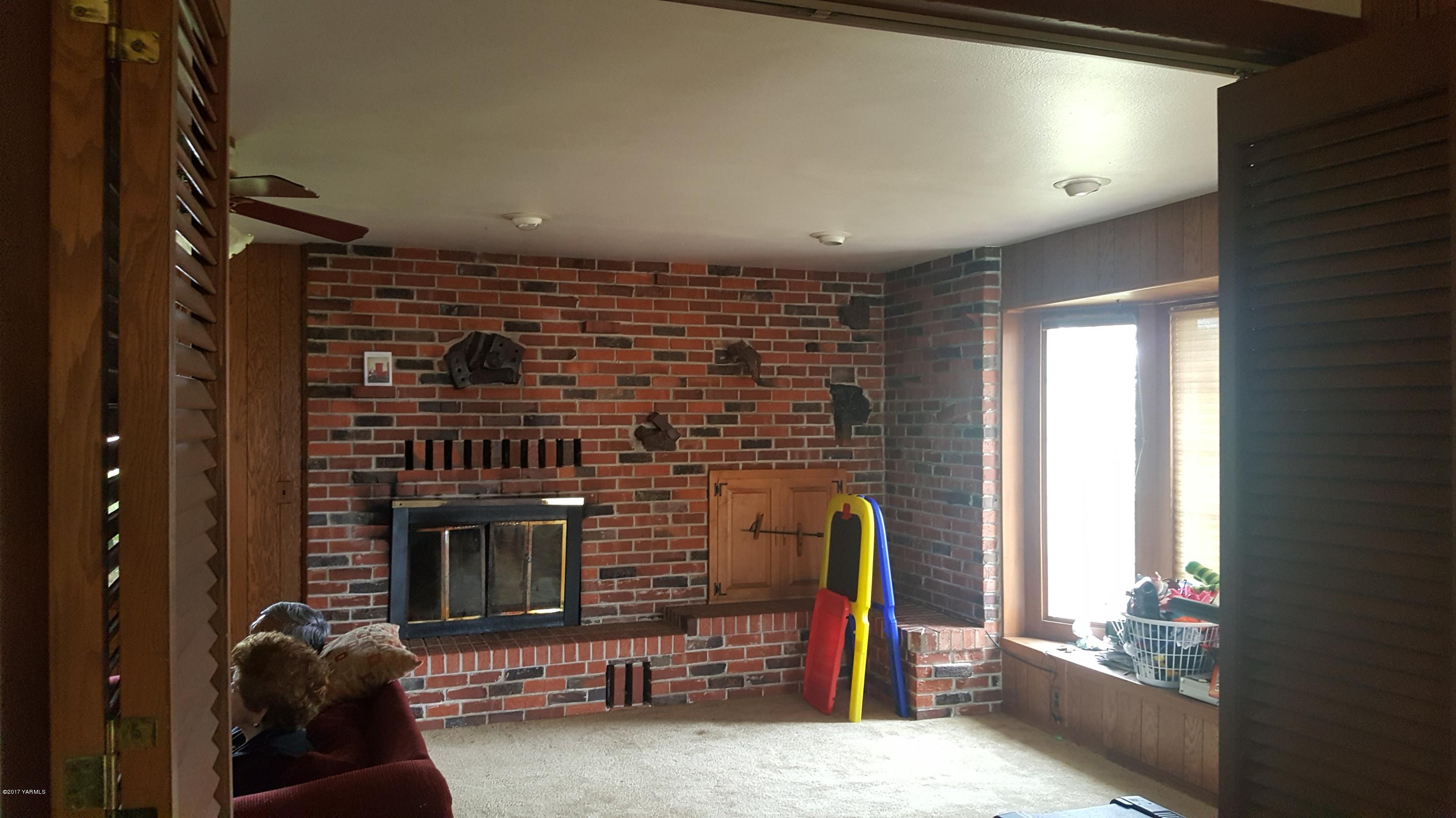 6530 Ashue Road Wapato, WA 98951 - Photo 3 of 14 a living room with furniture a flat screen tv and a fireplace