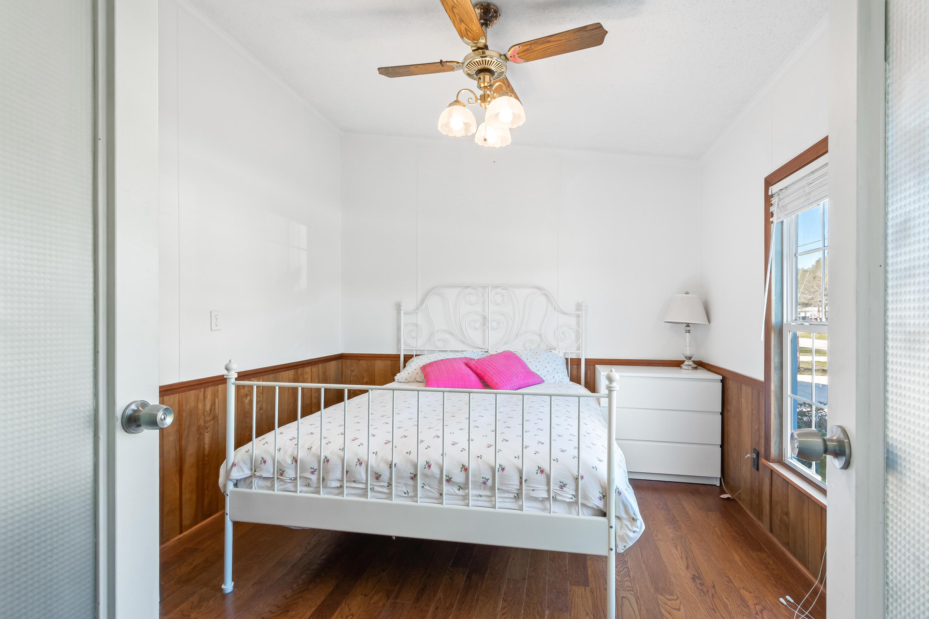 205 Treasure Beach Road St. Augustine, FL 32080 - Photo 27 of 43 a bedroom with a bed and a chandelier