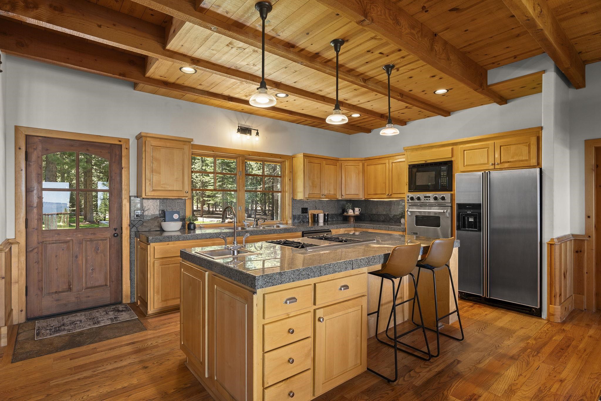 18168 La Mirada Road Truckee, CA 96161 - Photo 8 of 28 a kitchen with stainless steel appliances granite countertop a stove a refrigerator a kitchen island with chairs and wooden floor
