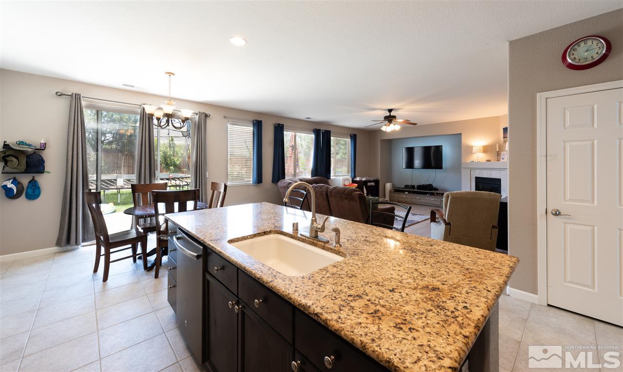 2480 Baton Drive Reno, NV 89521 - Photo 6 of 15 a large kitchen with kitchen island a stove a sink a dining table and chairs