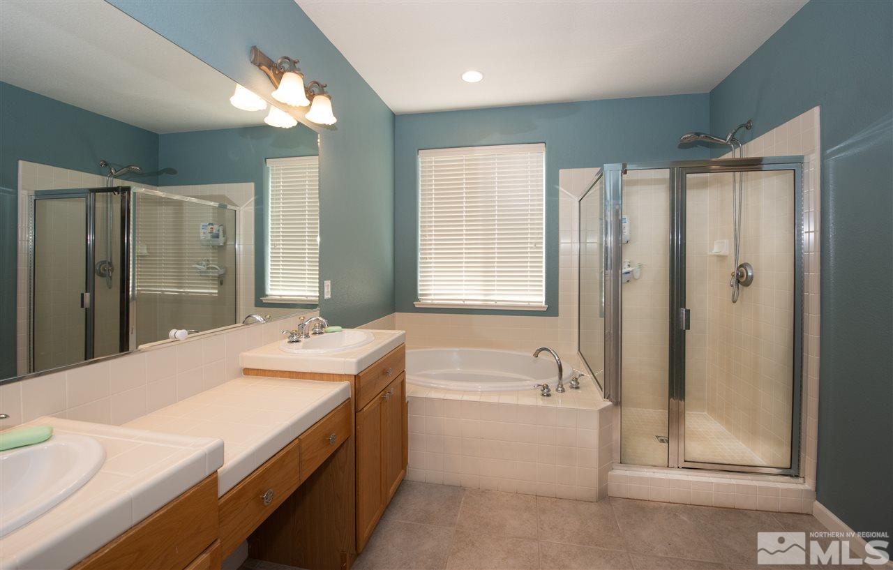 2480 Baton Drive Reno, NV 89521 - Photo 10 of 15 a spacious bathroom with a granite countertop sink a mirror a shower and a bathtub