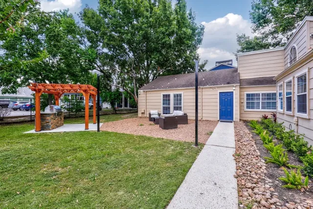 a view of house with wooden deck and a backyard