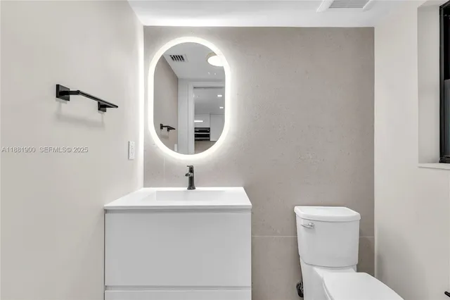 a bathroom with a toilet sink and mirror