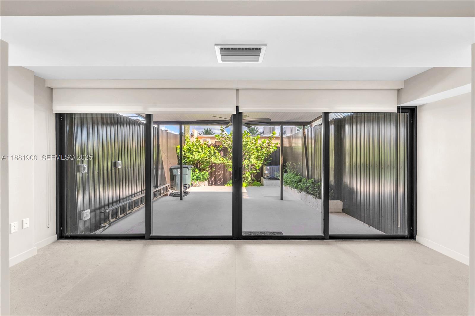 2211 Northeast 122nd Street, Unit 2211 North Miami, FL 33181 - Photo 15 of 34 an empty room with sliding glass door and mountain view