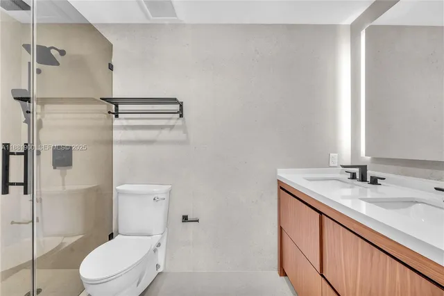 a bathroom with a granite countertop sink toilet and shower